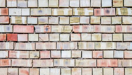 A wall of red baked brick as a background close-up