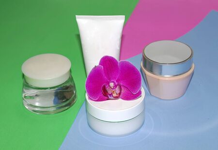 Face and body skin care. A set of white cosmetic tubes and cans on a pink background. Spa treatments at home.の写真素材