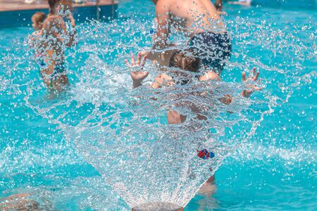 Fountain in the pool close-up. Children in the pool under water drops. Resort relaxation.の写真素材