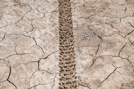 Traces of motorcycles on dry cracked ground as backgroundの写真素材