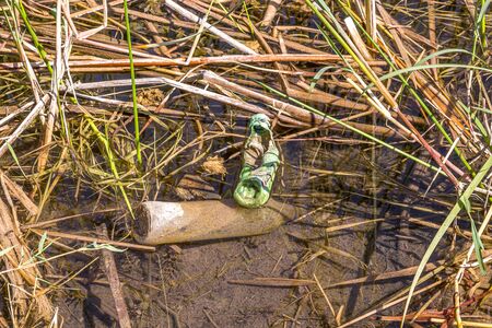 Plastic dishes trash in the water in natureの写真素材