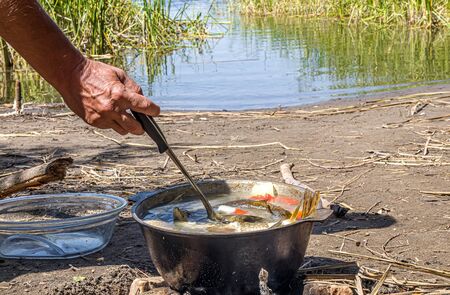 Cooking fish soup fish soup in the fire in natureの写真素材