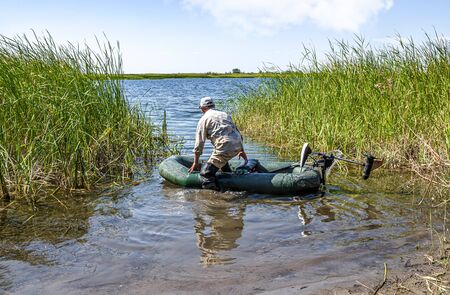 Man on an inflatable fishing boat in natureの写真素材
