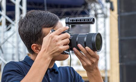 Close-up shot of a young photographer with a professional cameraの写真素材
