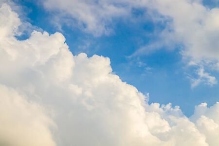 White clouds on a blue sky as a background for designの写真素材