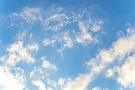 White clouds on a blue sky as a background for designの写真素材