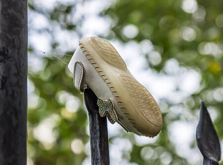 Lost baby shoes in the park on the fenceの写真素材