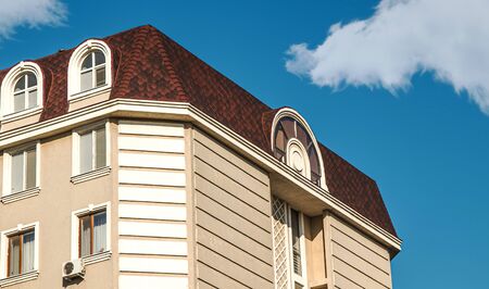 The building with a roof attic against the skyの写真素材