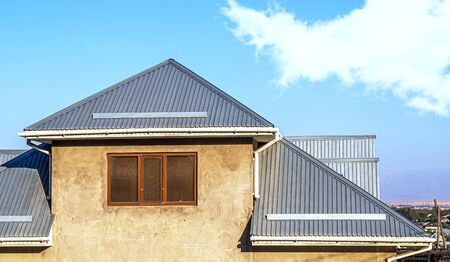 Roof of a house made of galvanized profile against the skyの写真素材