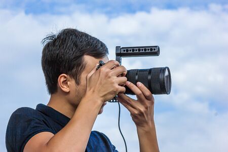 Close-up shot of a young photographer with a professional cameraの写真素材