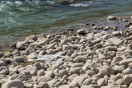 Round stones on the bank of a mountain river. Selective focus.