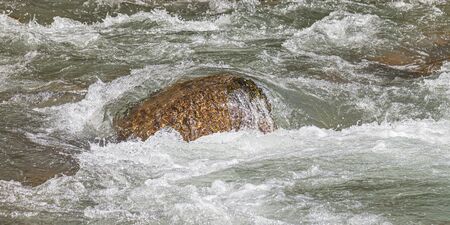 Boiling water in a mountain river as a backgroundの写真素材