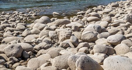 Round stones on the bank of a mountain river. Selective focus.の写真素材