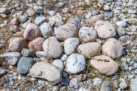 Round stones on the bank of a mountain river. Selective focus.の写真素材
