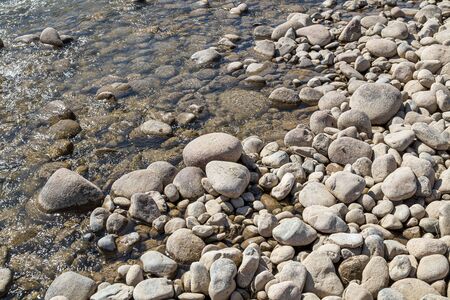 Round stones on the bank of a mountain river. Selective focus.の写真素材