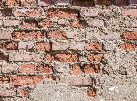 Wall of old weathered brick as a backgroundの写真素材