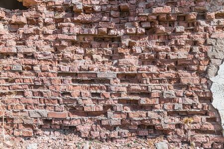 Wall of old weathered brick as a backgroundの写真素材