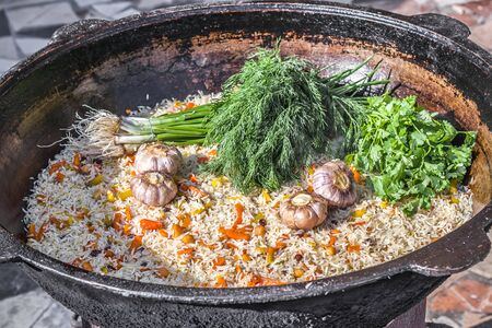 Close-up of national rice pilaf with spices and fresh herbs in a cauldronの写真素材