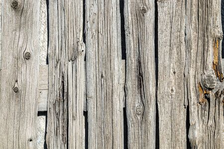 Fence wall made of old weathered wooden boards as backgroundの写真素材