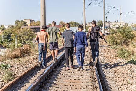 Young people teenagers walk on the railroad tracksの写真素材