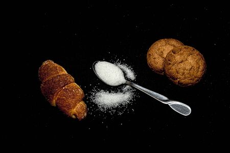 Sugar in a spoon on a black backgroundの写真素材