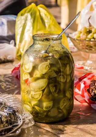 Glass jar with green tomatoes on the tableの写真素材