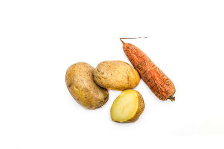 Boiled vegetables in a peel carrots and potatoes on a white backgroundの写真素材