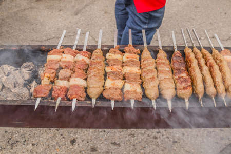 The meat is fried on skewers on the coals.Cooking delicious barbecue on the grillの写真素材