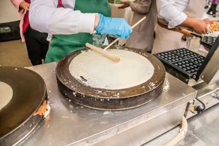Making Russian pancakes with filling on an industrial scale in a cafe.の写真素材