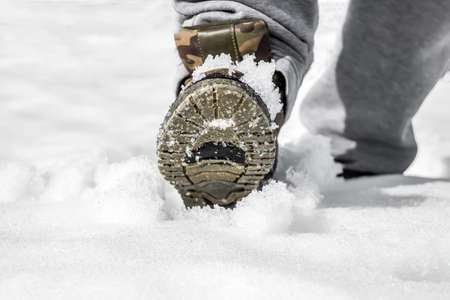 Shoes in the snow close-up. A man walks on fresh snow.の写真素材