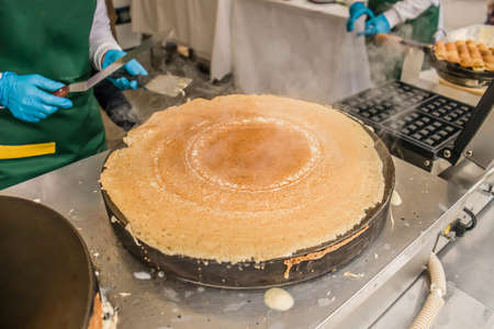 Making Russian pancakes with filling on an industrial scale in a cafe.の写真素材