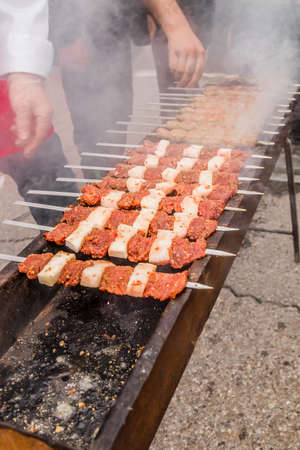 The meat is fried on skewers on the coals.Cooking delicious barbecue on the grillの写真素材