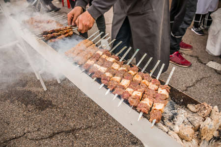 The meat is fried on skewers on the coals.Cooking delicious barbecue on the grillの写真素材