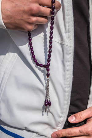 Rosary beads in the hands of a young manの写真素材