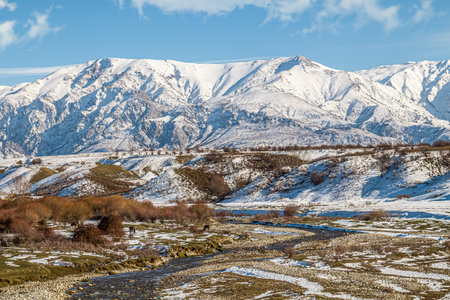 River valley against the backdrop of snow-capped mountains.の写真素材