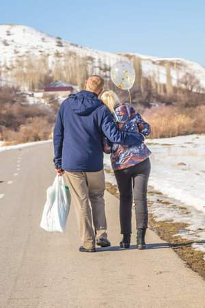 Loving couple walks along a mountain road rear view.の写真素材