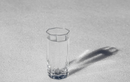 Glass cup with cold water on white snow.