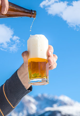 Glass cup with cold beer against the sky.の写真素材