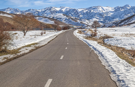 Old road asphalt in the winter in the highlands. mountain landscape.の写真素材