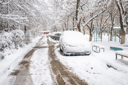 Car under the snow in the yard in the cityの写真素材