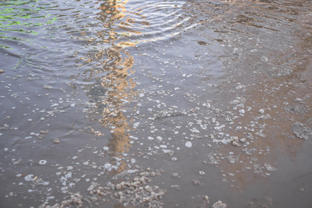 Muddy puddle on the road from melting snowの写真素材