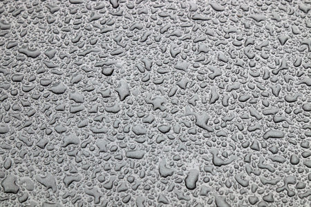 Dusty drops of water on the glass and hood of a carの写真素材