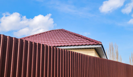 The roof of the house from a metal profile - a metal slate against the skyの写真素材
