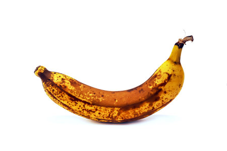 Ripe banana with spots isolated on white studio backgroundの写真素材