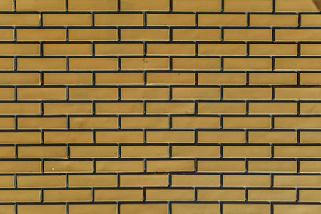 The texture of the stone. Ceramic tiles as a background. Brickwork made of artificial stone. Yellow brick wall. Tekxure brick wall background.の写真素材