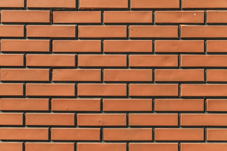 The texture of the stone. Ceramic tiles as a background. Brickwork made of artificial stone. Yellow...
