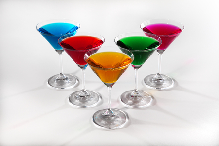 Group of glasses with colored beverages on white backgroundの写真素材
