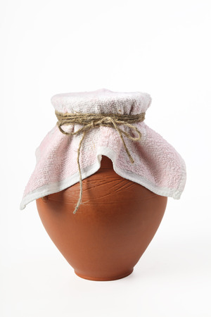 A ceramic jug covered with a cloth napkin. Isolated on a white backgroundの写真素材