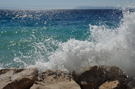 Big wave on beach with stones in Podgora with horizon in backgroundの写真素材