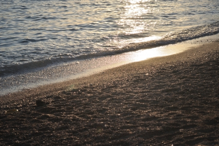 Evening waves on the beach with glistening seaの写真素材